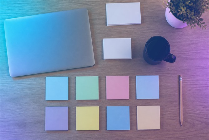 Desk with blank sticky notes and a laptop arranged for strategy planning